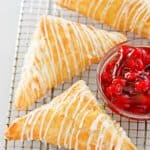 three homemade Arby's cherry turnovers and a small bowl of cherry pie filling