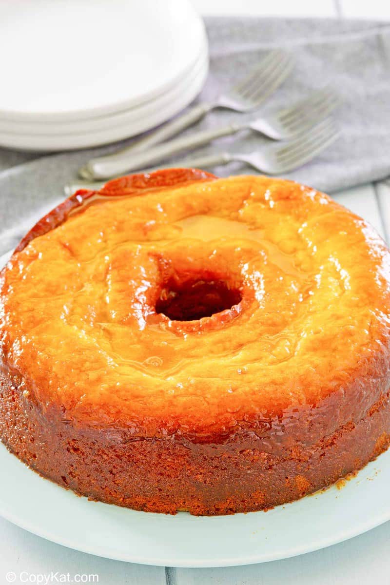 Bacardi rum cake on a platter, stack of plates, and forks.