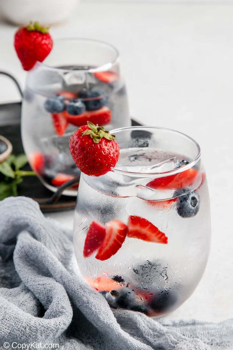 glasses of fruit infused water and fresh fruit.
