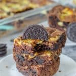 three Oreo brownies on a plate with a bite out of one