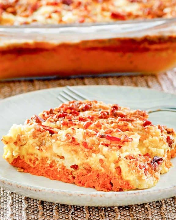 pumpkin dump cake slice on a plate in front of the cake