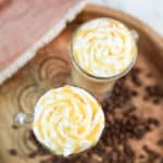 overhead view of two homemade Starbucks caramel macchiato coffee drinks on a tray