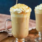 drizzling caramel sauce on top of a homemade Starbucks caramel macchiato.