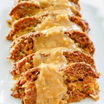 sliced of stuffed meatloaf with gravy on a platter