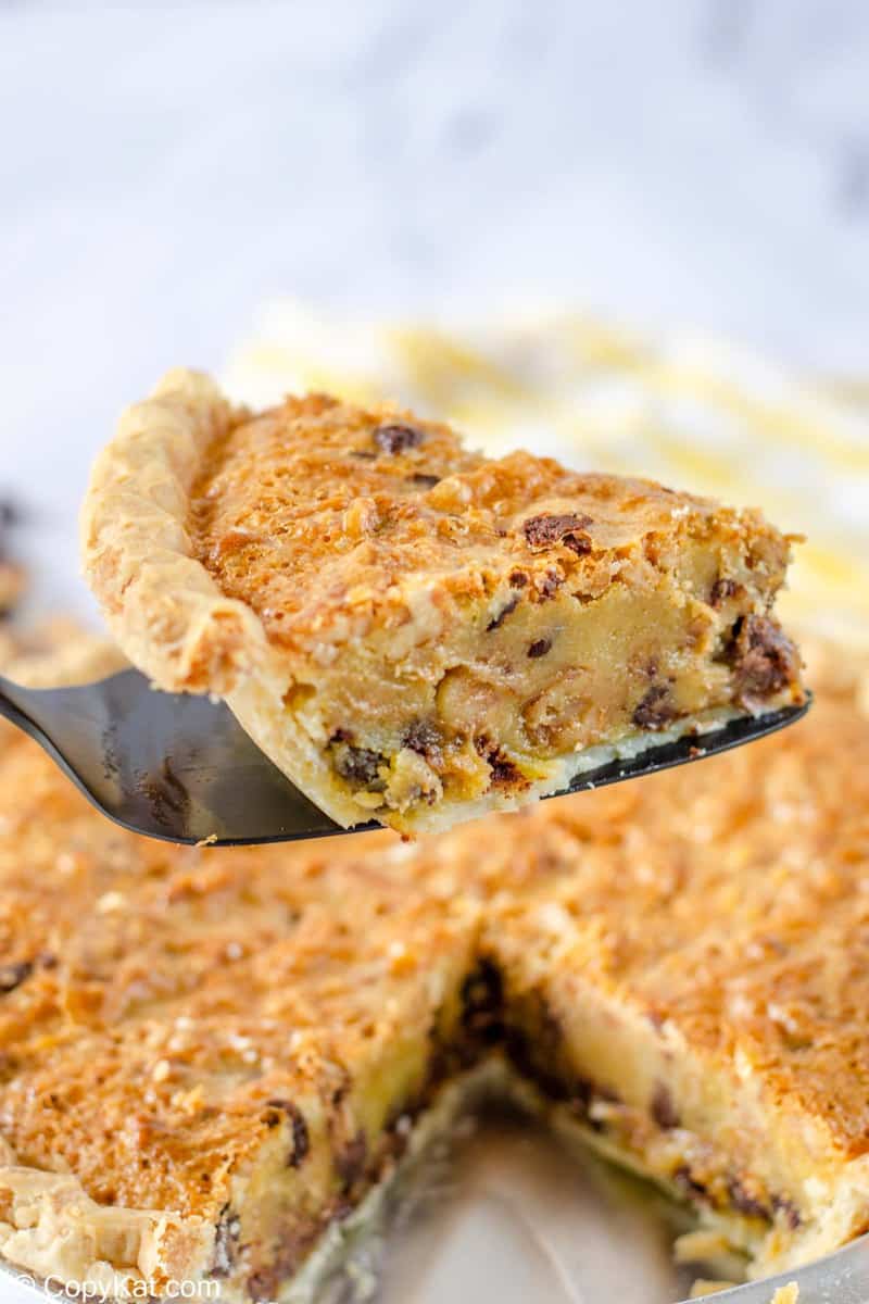 a slice of Toll House Pie on a spatula over the pie