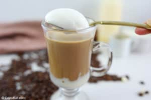 a spoonful of frothed milk foam over a white chocolate mocha.