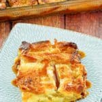 apple bread pudding topped with caramel sauce on a plate.