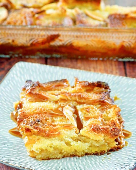 apple bread pudding with caramel sauce on a plate.