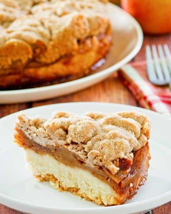a slice of apple coffee cake with crumb topping on a plate.