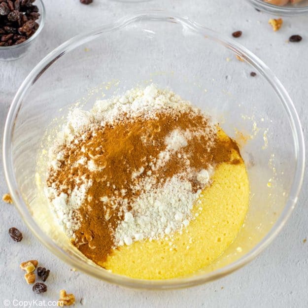 adding dry ingredients to wet ingredients for spice cake.