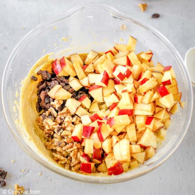adding walnuts, raisins, and chopped apples to spice cake batter.