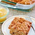 applesauce cake slice on a plate and the cake in a glass baking dish.