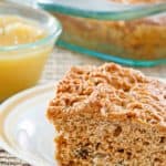 a slice of applesauce cake on a plate and applesauce in a small bowl.