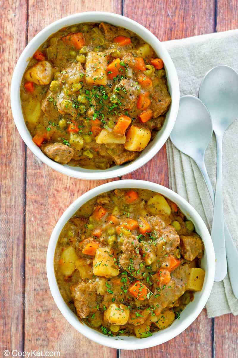 overhead view of two bowls of Dutch oven beef stew and two spoons.