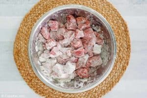 floured round steak pieces in a bowl.