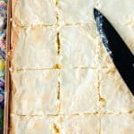 sliced gooey butter cake in the pan and a knife.