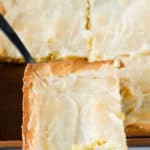 gooey butter cake slice on a cake server over the cake.