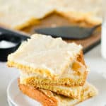 four gooey butter cake slices on a plate in front of the cake in a pan.
