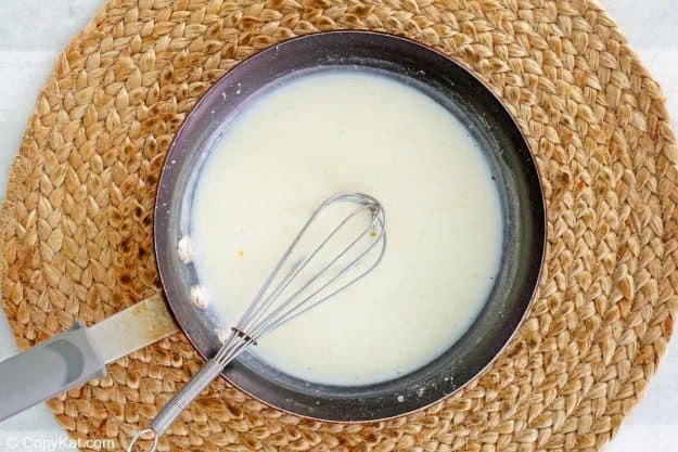 milk mixture for green bean casserole with cheese in a pan.