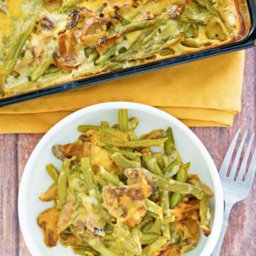 overhead view of green bean casserole with cheese in a baking dish and on a plate.