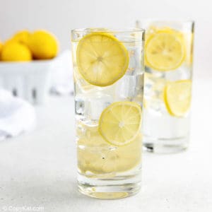 homemade lemonade, ice, and lemon slices in two glasses.
