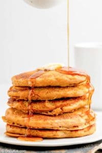 a stack of homemade IHOP pumpkin pancakes with syrup flowing over them.
