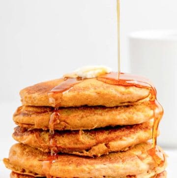 a stack of homemade IHOP pumpkin pancakes with syrup flowing over them.