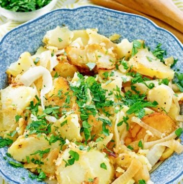 lyonnaise potatoes in a blue serving bowl.
