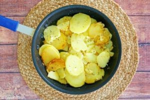 browned potato slices in a skillet.
