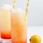 two glasses of homemade McDonald's frozen strawberry lemonade and lemons.