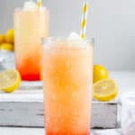 homemade McDonald's frozen strawberry lemonade, lemons, and a kitchen towel.