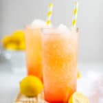 two glasses of homemade McDonald's frozen strawberry lemonade on a wood board.