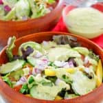 homemade Chick-Fil-A avocado lime ranch dressing on a salad and in a small bowl.