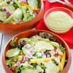 homemade Chick Fil A avocado lime ranch dressing on salad and in a bowl.