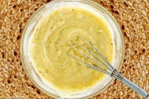 mashed potato pancakes batter and a whisk in a bowl.
