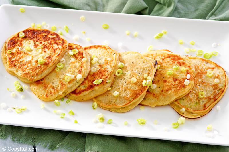 six fried mashed potato pancakes on a platter.
