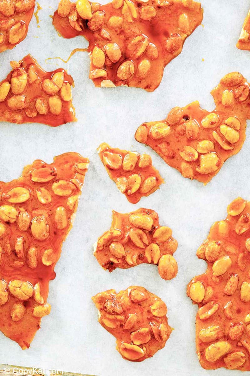 overhead view of microwave peanut brittle pieces on parchment paper.