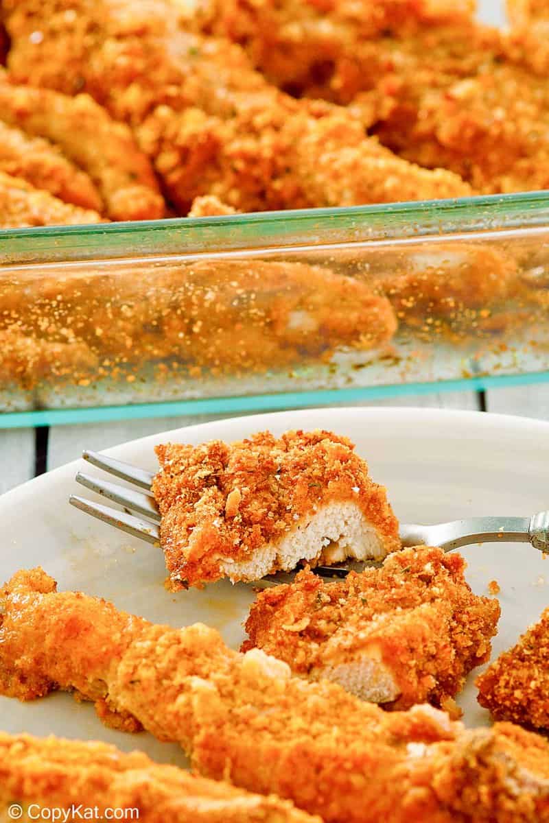Ritz cracker chicken tenders on a plate and in a baking dish.