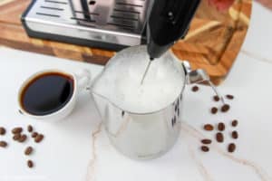frothing milk for a Starbucks flat white coffee.