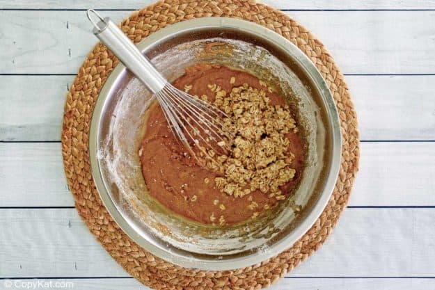 oatmeal cake batter and a whisk in a mixing bowl.
