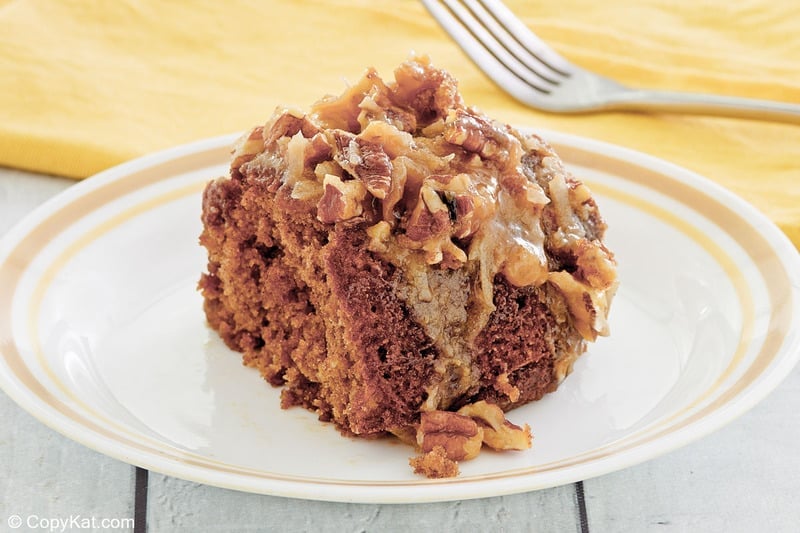 slice of oatmeal cake with coconut pecan frosting on a plate.