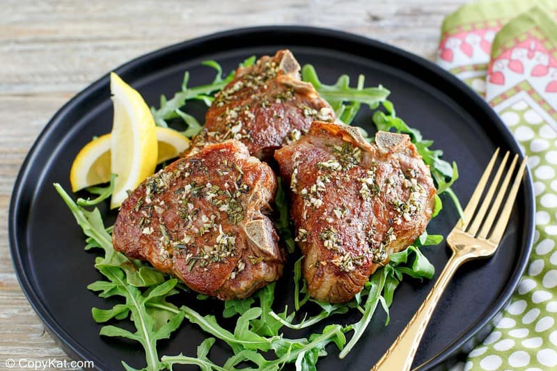 pan seared lamb chops on a black plate.
