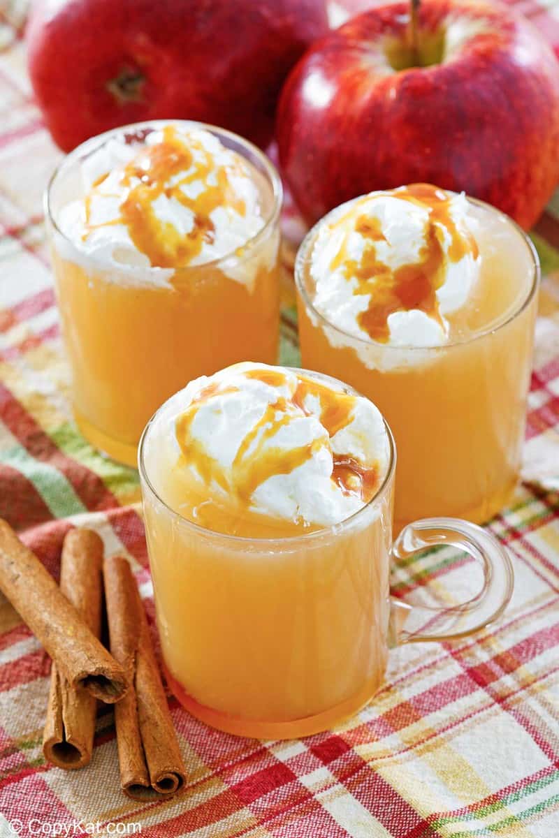 homemade Starbucks caramel apple drink, cinnamon sticks, and apples.