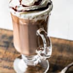 homemade Starbucks hot chocolate in a glass mug on a wood board.