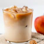 homemade Starbucks iced apple crisp macchiato, cinnamon sticks, and an apple.