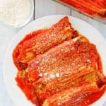 overhead view of stuffed manicotti on a plate and in a baking dish.
