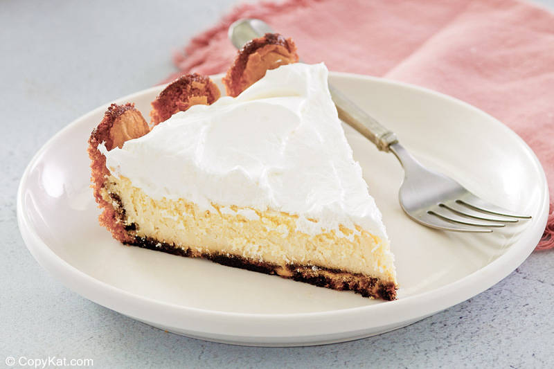 tiramisu cheesecake slice on a plate with a fork next to it.