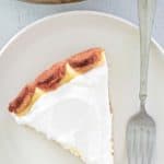 overhead view of tiramisu cheesecake slice and a fork on a plate.
