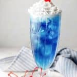 homemade Ruby Tuesday Blue Smurf Punch Drink and a bowl of maraschino cherries.