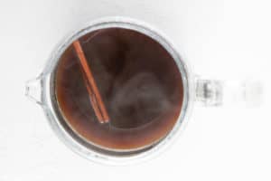 brewed cinnamon coffee and cinnamon sticks in a coffee pot.